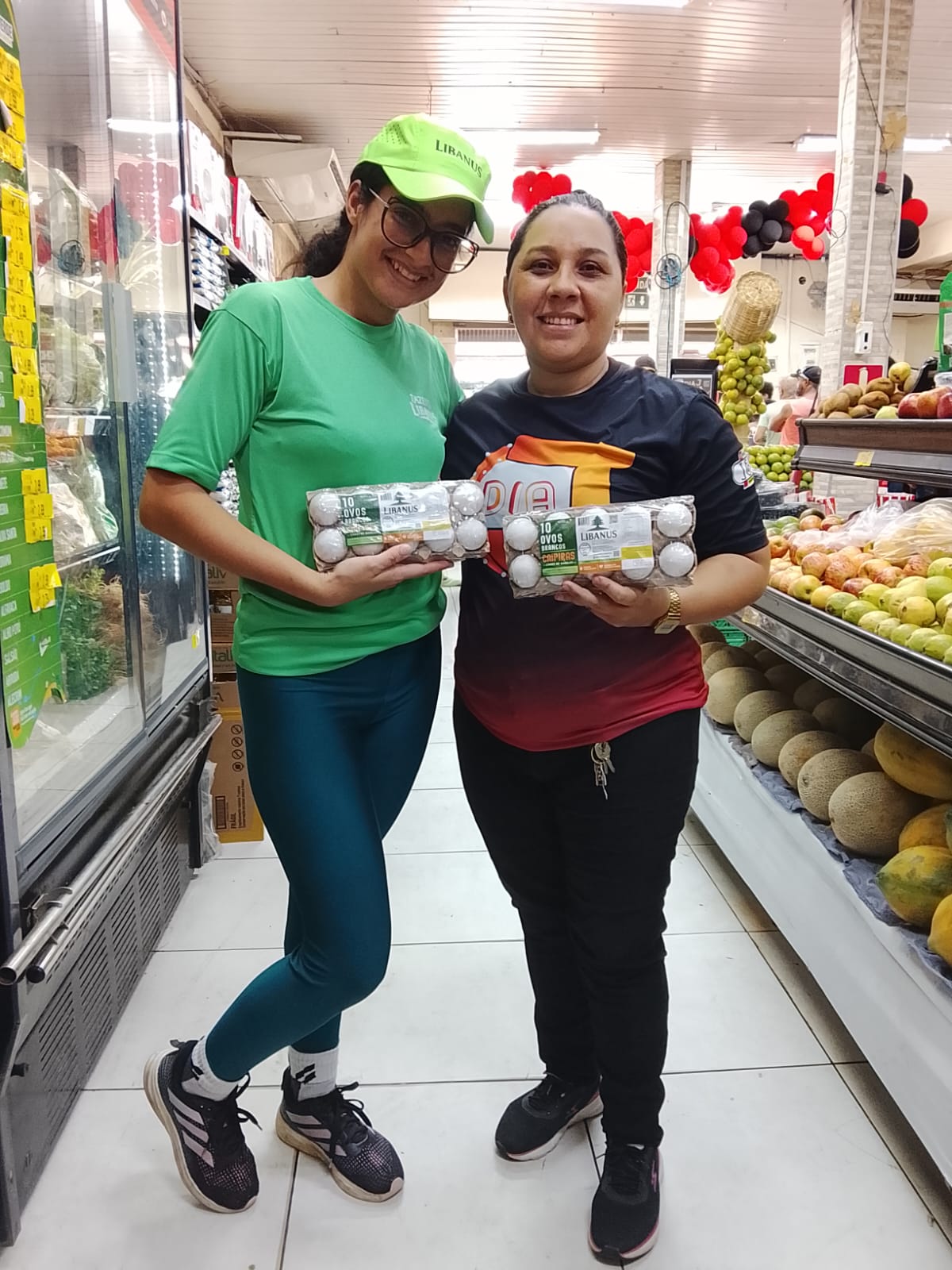 Promotora Libanus e cliente sorrindo em supermercado do Vale do Curu segurando bandejas de ovos brancos caipiras Libanus